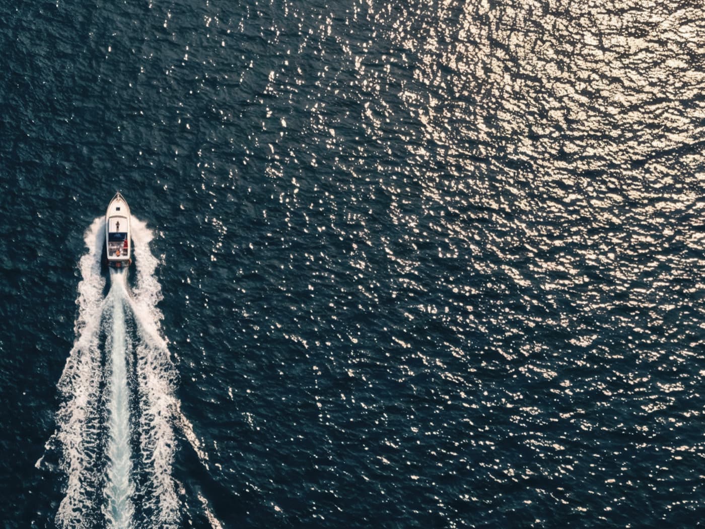 Vue aérienne d'un bateau traçant son sillage sur la mer Noire, à contre-jour
